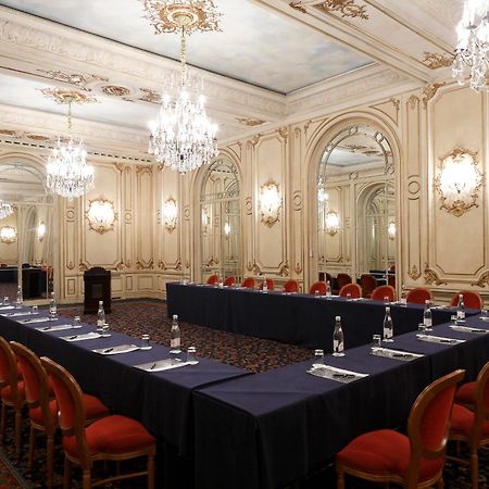 Hotel Le Plaza Bruselas Facilidades foto The photo shows an elegantly designed conference or meeting room. The room features ornate decorations, with detailed molding and classic architectural elements. There are several chandeliers hanging from the ceiling, providing warm lighting. A large