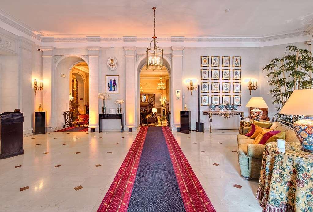 Hotel Le Plaza Bruselas Interior foto The photo shows an elegant and spacious hallway or entrance area of a home. The space features high ceilings and detailed architectural elements, such as arches. There is a long, decorative red carpet running down the center, flanked by polished marb