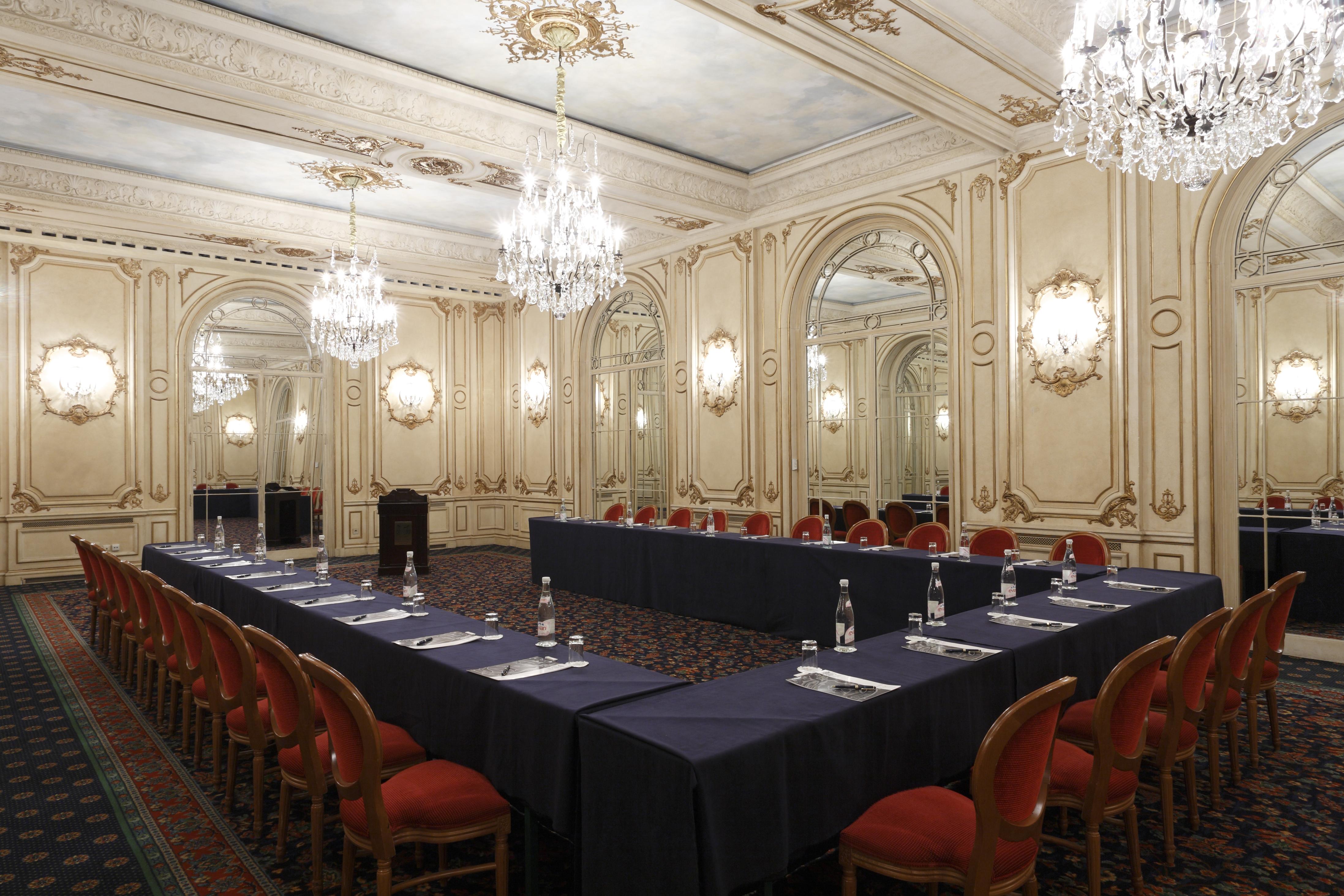 Hotel Le Plaza Bruselas Facilidades foto The photo shows an elegantly designed conference or meeting room. The room features ornate decorations, with detailed molding and classic architectural elements. There are several chandeliers hanging from the ceiling, providing warm lighting. A large