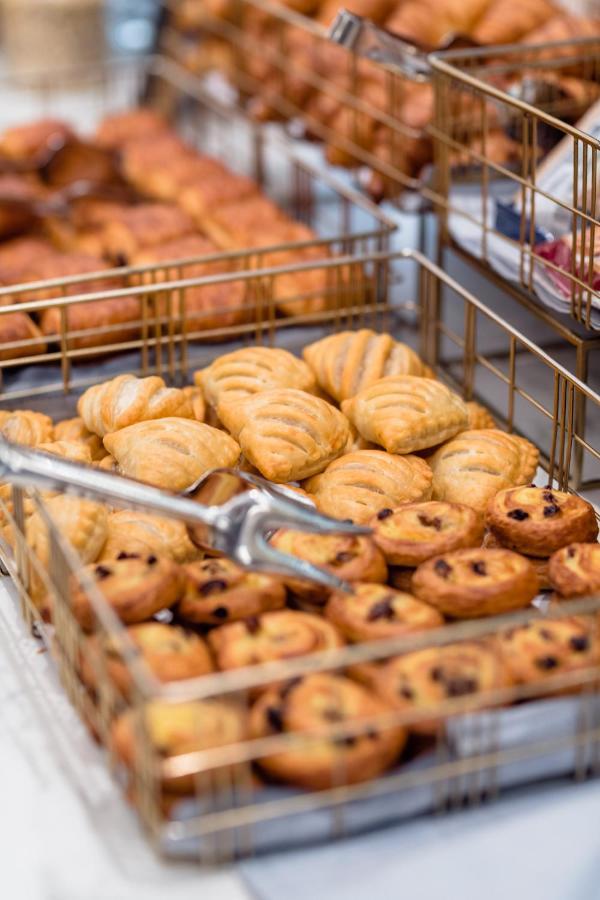 Hotel Le Plaza Bruselas Exterior foto The photo shows a display of baked goods in a basket. There are two types of pastries: one variety appears to be flaky and golden-brown with a distinctive wavy pattern, while the other variety consists of circular pastries with a swirled design that 