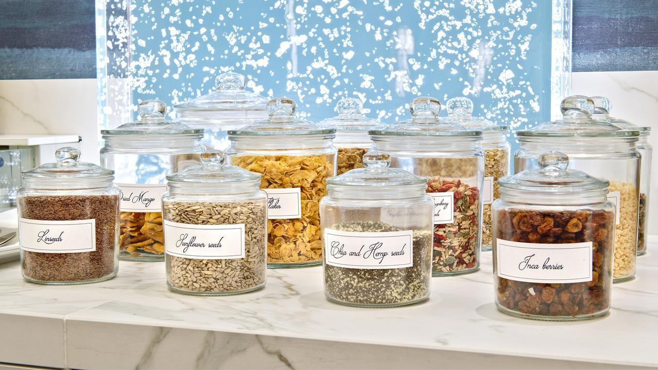 Hotel Le Plaza Bruselas Exterior foto The photo shows a collection of clear glass jars filled with various spices, herbs, and possibly dried ingredients. Each jar is labeled with a name, indicating the contents inside. The jars are displayed on a countertop, and the background features a